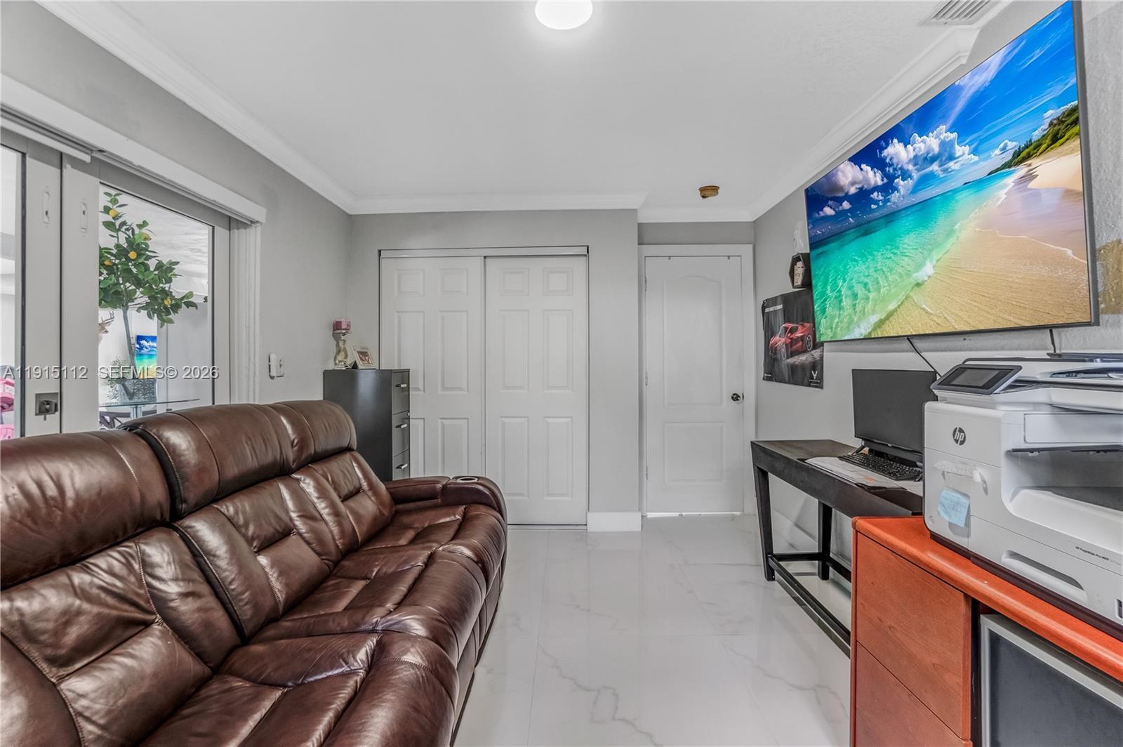 12601 Southwest 204th Street Miami, FL 33177 - Photo 33 of 40 a living room with furniture a flat screen tv and floor to ceiling window