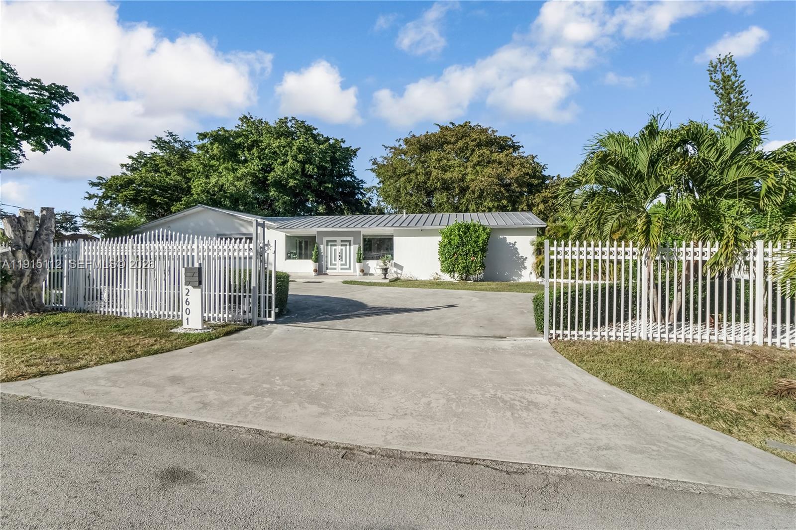 12601 Southwest 204th Street Miami, FL 33177 - Photo 5 of 40 a front view of a house with a garden and trees