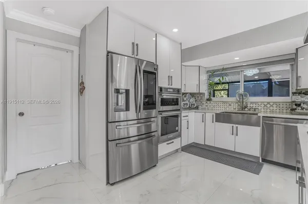 a kitchen with white cabinets and stainless steel appliances