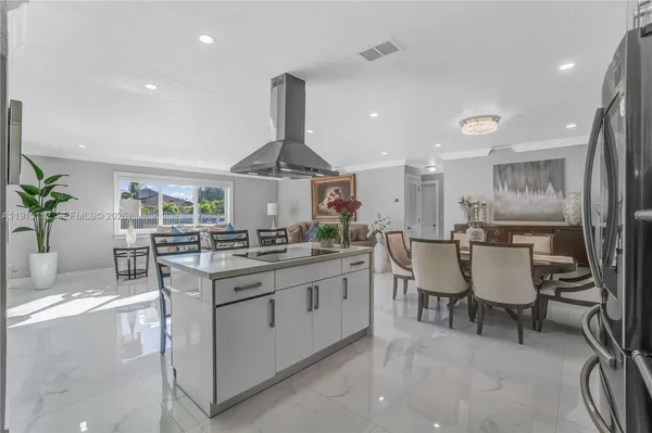 a kitchen with stainless steel appliances a sink a stove a table and chairs
