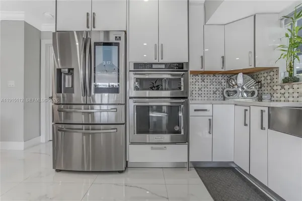 a kitchen with stainless steel appliances granite countertop a refrigerator and a stove top oven