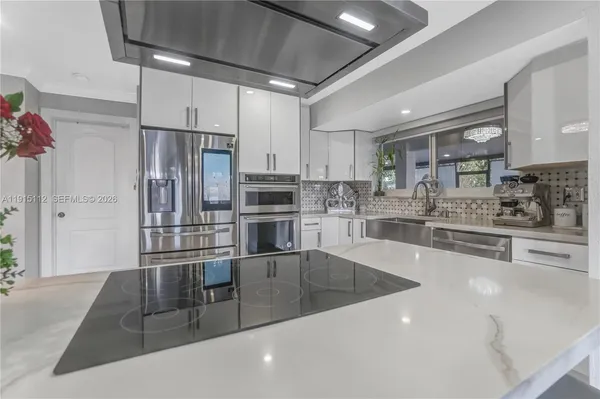 a kitchen with stainless steel appliances a sink a stove and cabinets
