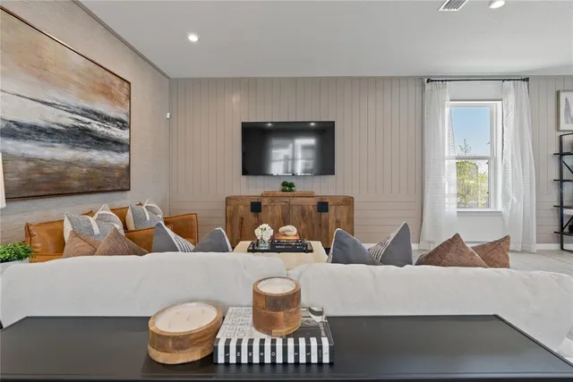 a bedroom with bed a table and a large mirror