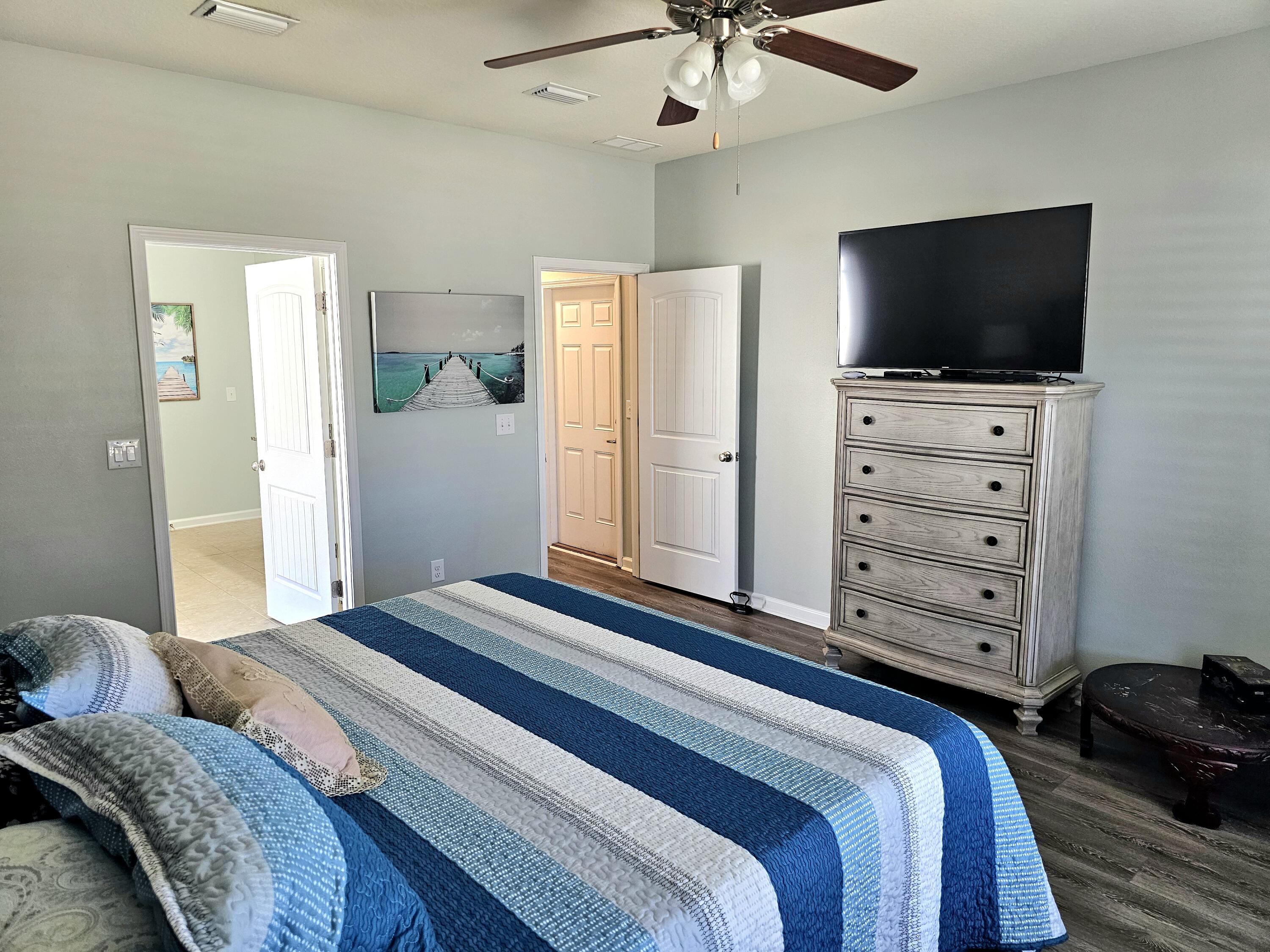 140 Nelly Street Freeport, FL 32439 - Photo 26 of 53 a bedroom with a bed and a flat tv screen on dresser