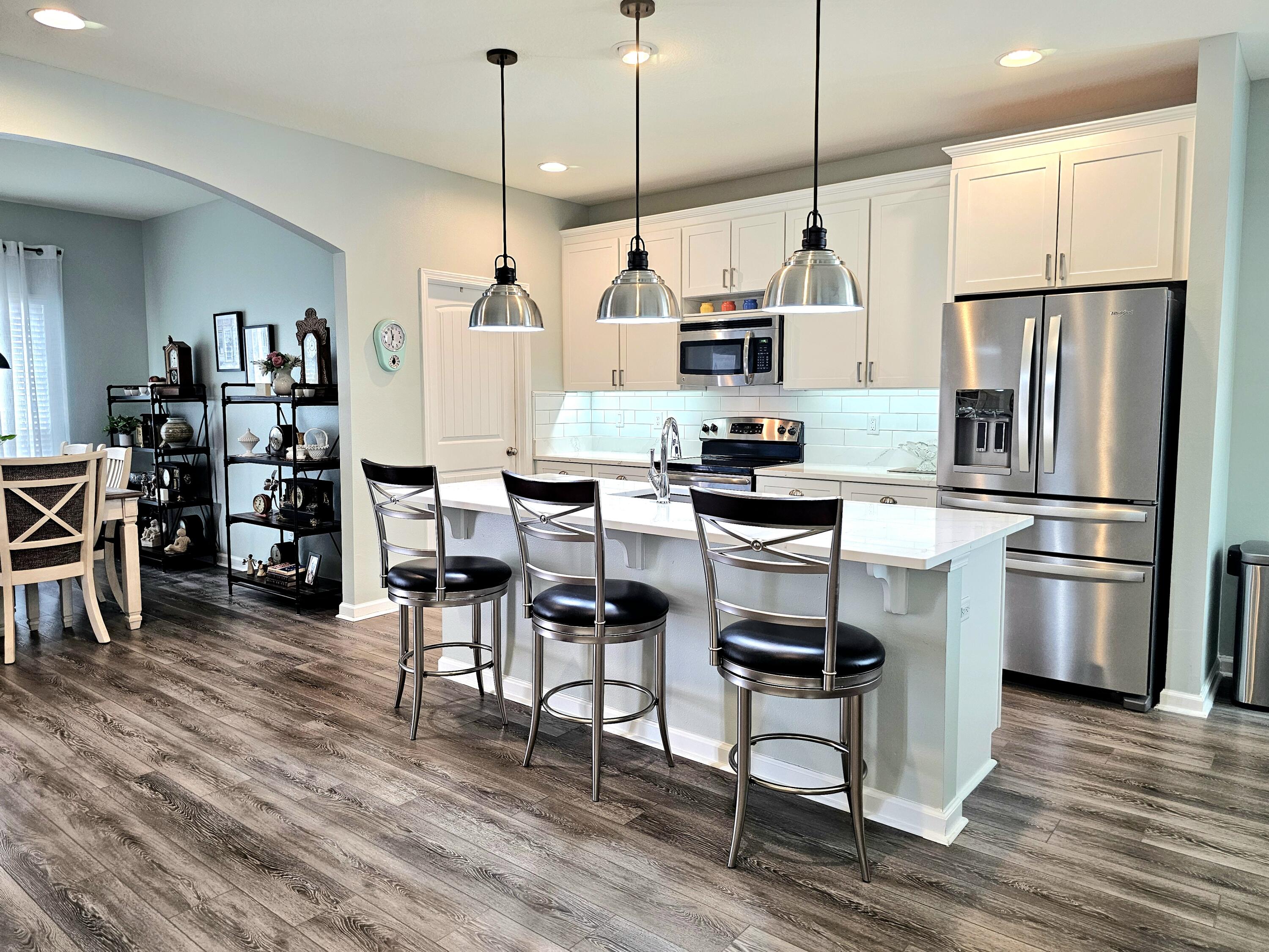 140 Nelly Street Freeport, FL 32439 - Photo 6 of 53 a kitchen with stainless steel appliances kitchen island granite countertop a table chairs and a refrigerator