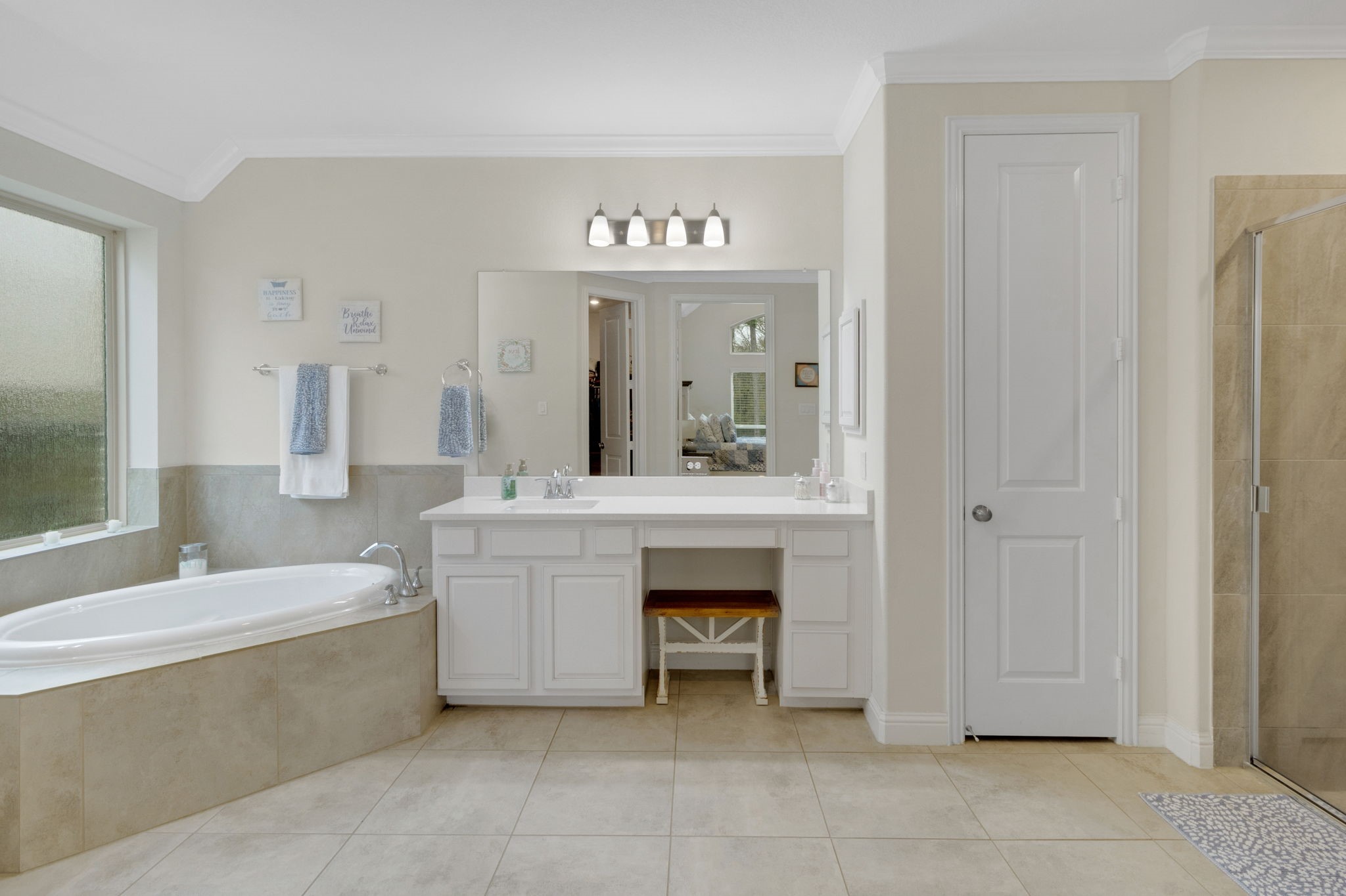 19248 Yellow Chestnut Lane New Caney, TX 77357 - Photo 16 of 42 a bathroom with a sink a large mirror and a bathtub