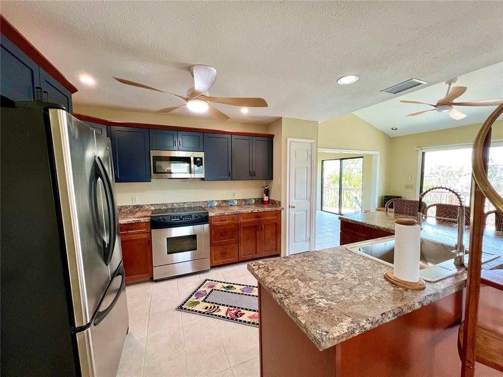 9580 Almirate Court Placida, FL 33946 - Photo 20 of 59 a kitchen with stainless steel appliances granite countertop a stove refrigerator and a sink