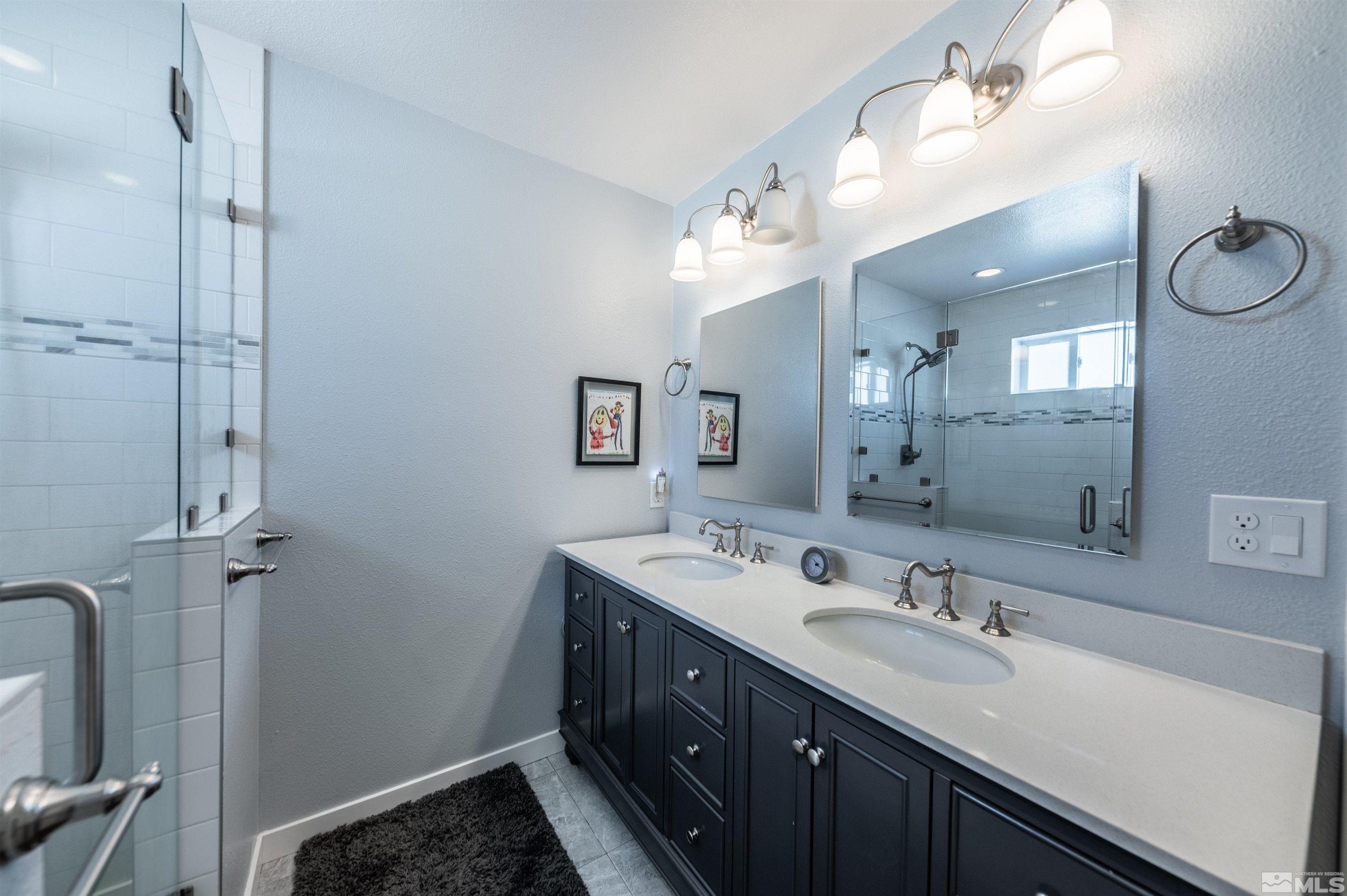 1325 Sharon Way Reno, NV 89509 - Photo 20 of 40 a bathroom with a double vanity sink a mirror and a shower