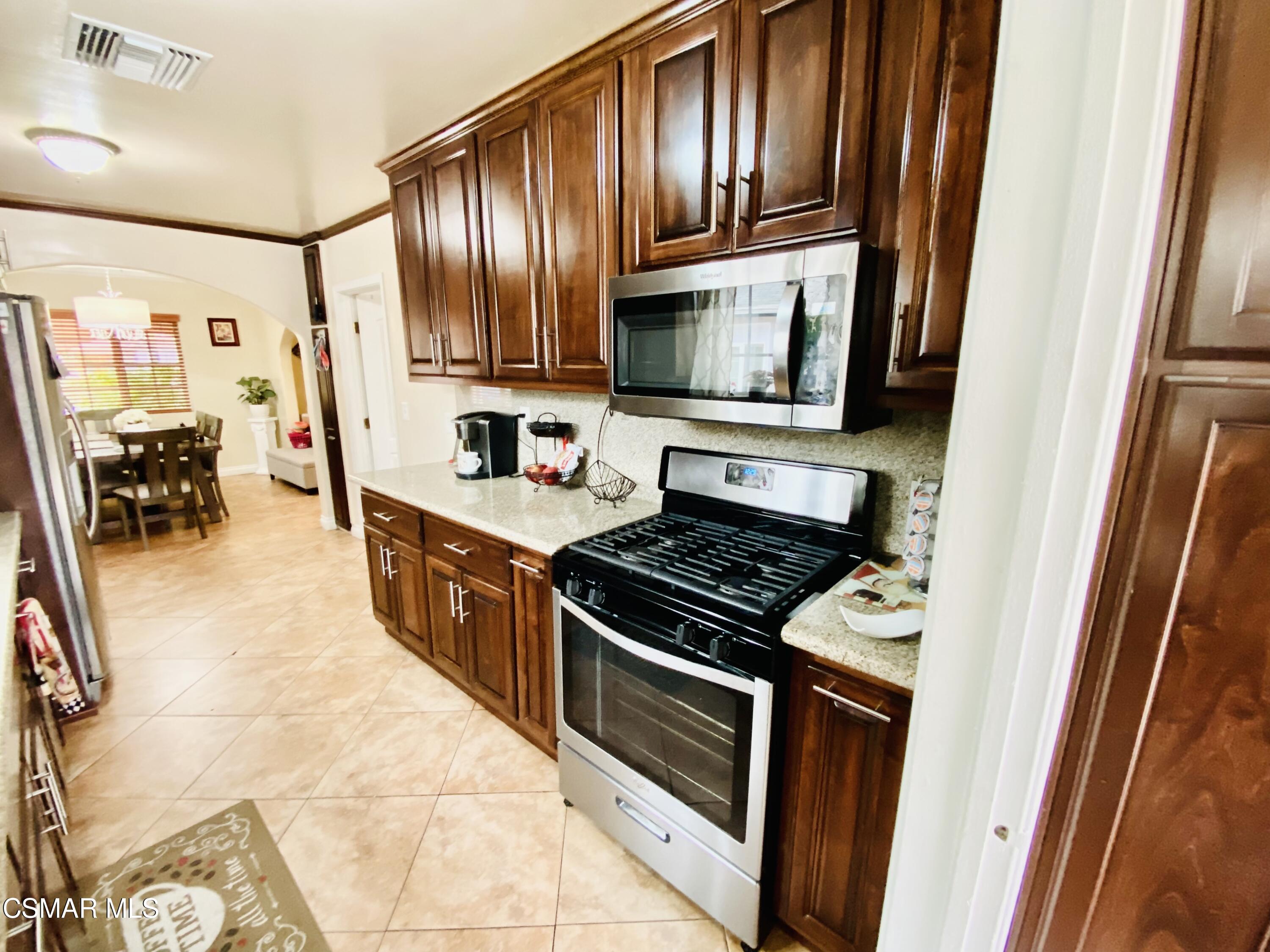 13628 Wingo Street Arleta, CA 91331 - Photo 15 of 55 a kitchen with stainless steel appliances granite countertop a stove and a refrigerator