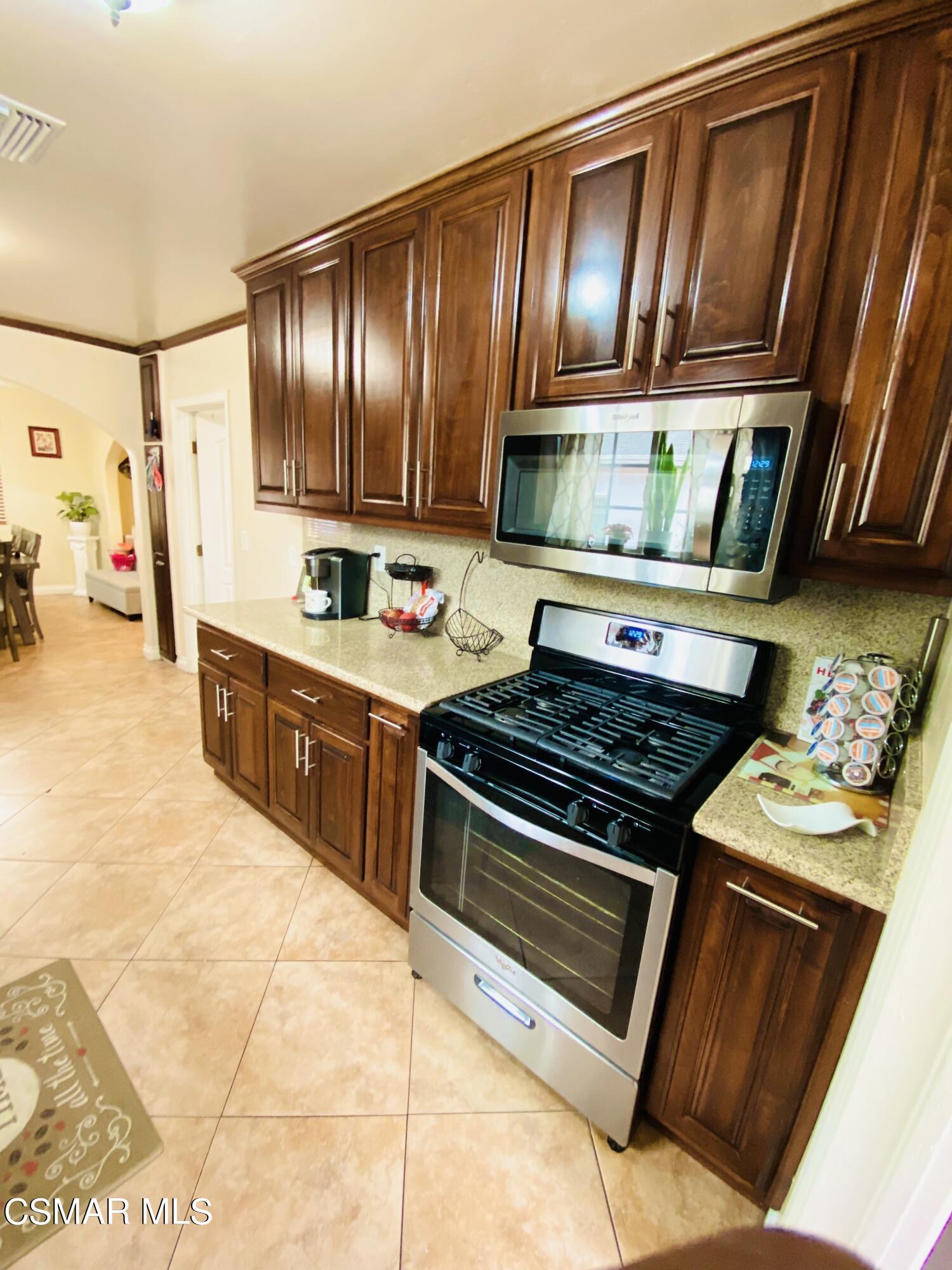 13628 Wingo Street Arleta, CA 91331 - Photo 16 of 55 a kitchen with wooden cabinets and a stove top oven