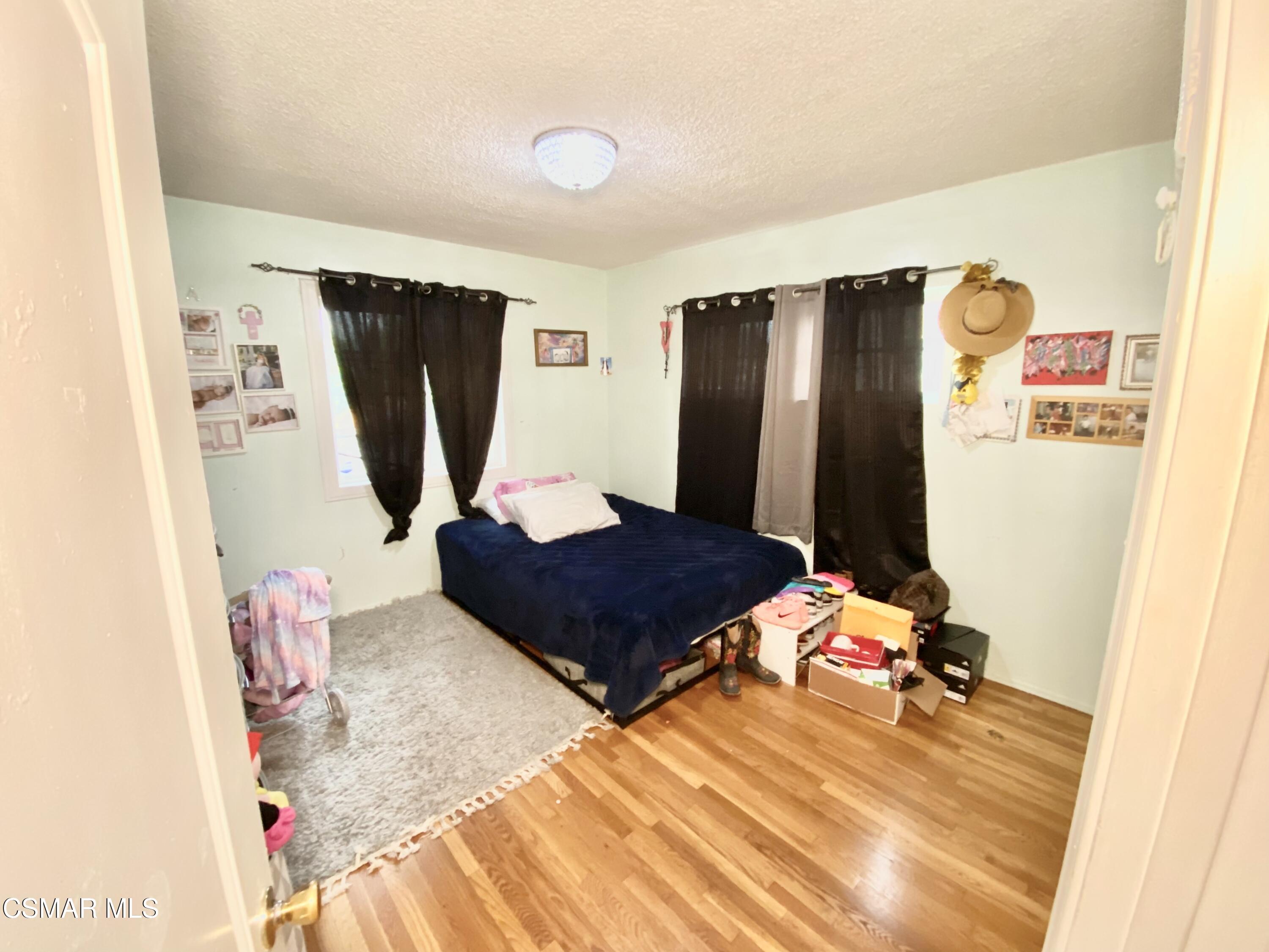 13628 Wingo Street Arleta, CA 91331 - Photo 27 of 55 a bedroom with a bed and a refrigerator