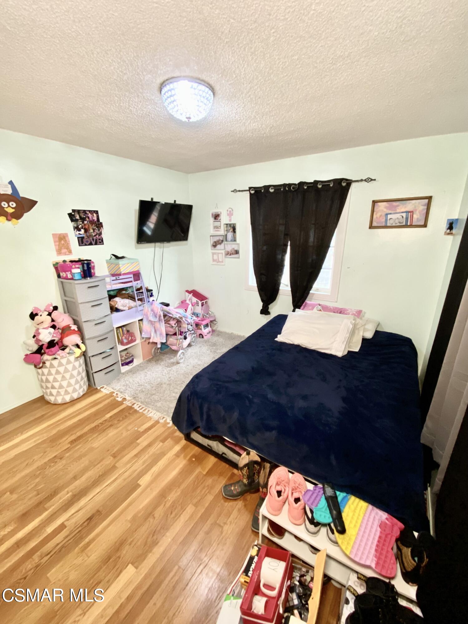 13628 Wingo Street Arleta, CA 91331 - Photo 29 of 55 a bedroom with a bed and flat screen tv