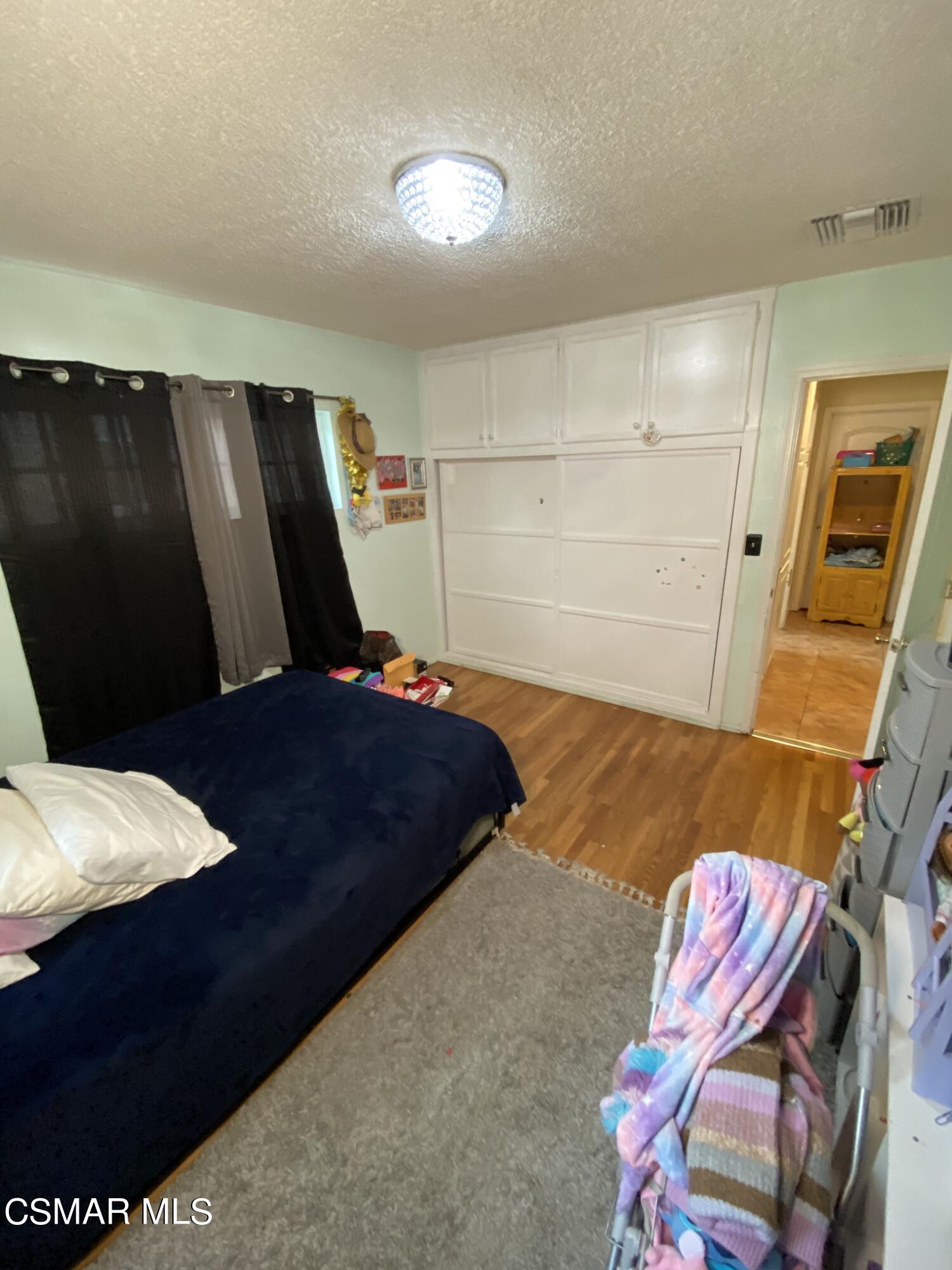 13628 Wingo Street Arleta, CA 91331 - Photo 30 of 55 a bedroom with a bed and wooden floor