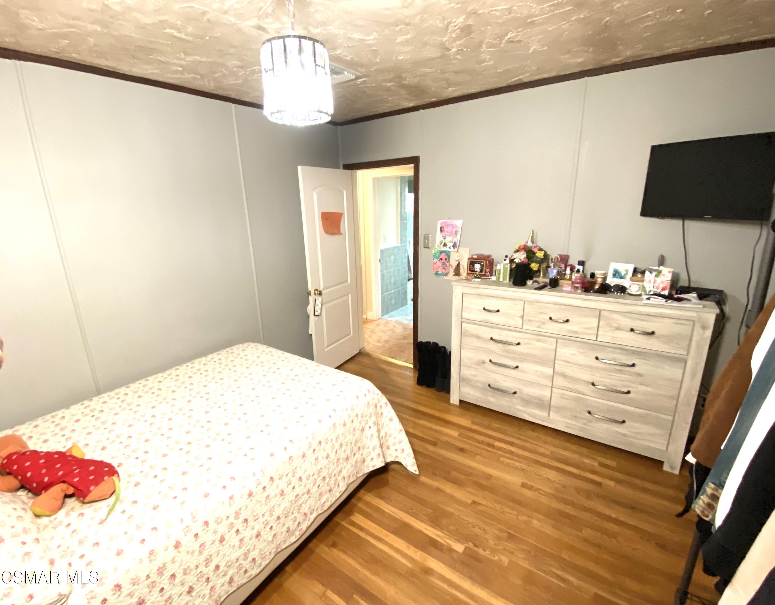 13628 Wingo Street Arleta, CA 91331 - Photo 39 of 55 a bedroom with a bed and a flat tv screen on dresser