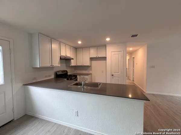 a view of an empty room and kitchen view