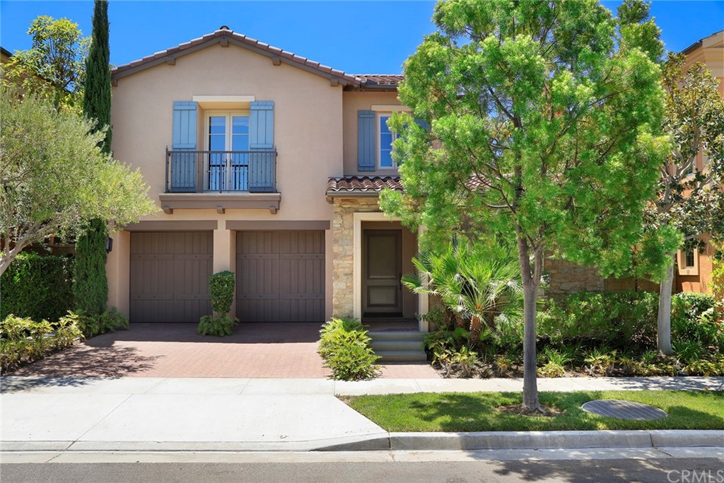 a front view of a house with a yard and potted plants