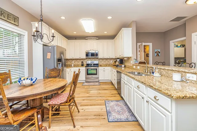 a large kitchen with stainless steel appliances kitchen island granite countertop a sink and cabinets