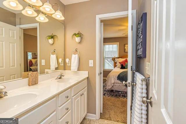a en suite bathroom with a granite countertop sink and a mirror
