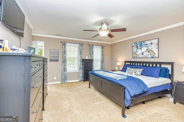 a spacious bedroom with a large bed and a chandelier