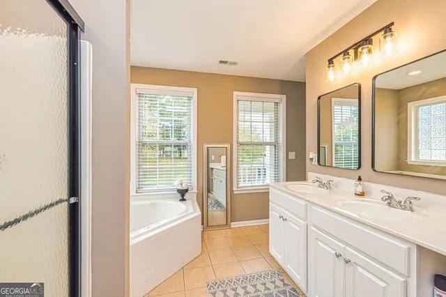 a spacious bathroom with sink shower and bathtub