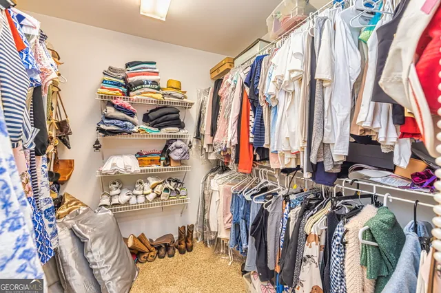 a view of walk in closet with clothes