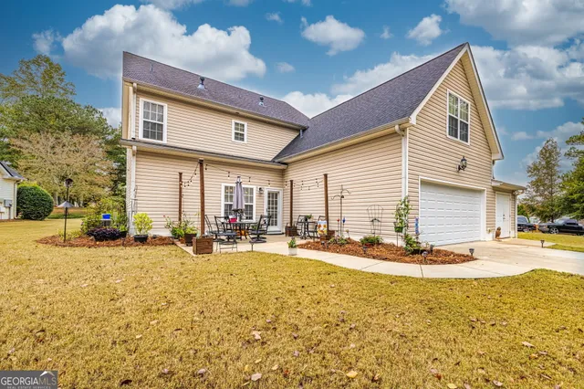 a view of a house with backyard and sitting area