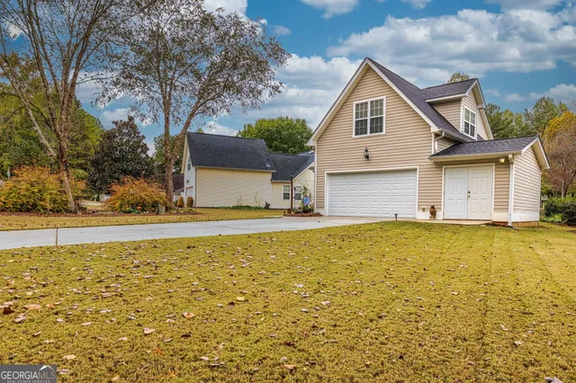 a front view of house with yard and ocean
