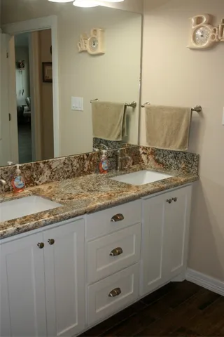 a bathroom with a granite countertop sink and a mirror