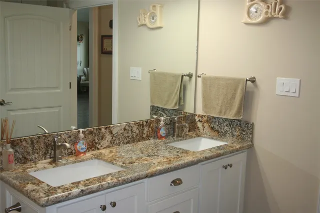 a bathroom with a granite countertop sink and a mirror