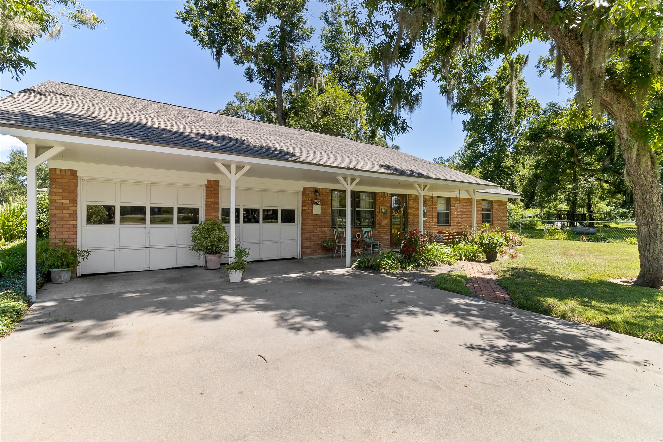 1971 FM 522 Road Brazoria, TX 77422 - Photo 1 of 26 A charming first impression with mature shade trees, established landscaping and a covered front porch spanning the home and two-car garage.