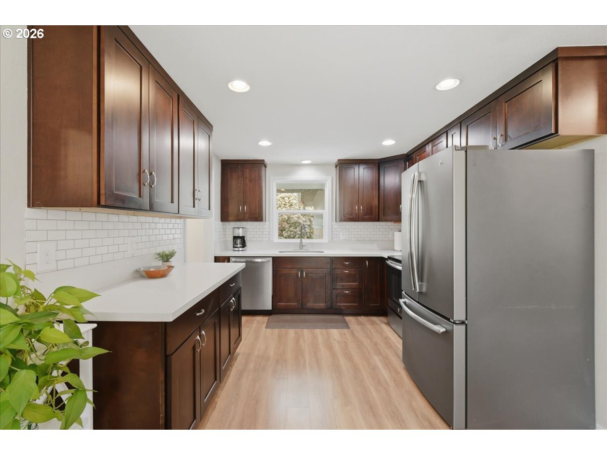 4620 Southwest 183rd Court Beaverton, OR 97078 - Photo 7 of 34 a kitchen with kitchen island granite countertop wooden cabinets and stainless steel appliances
