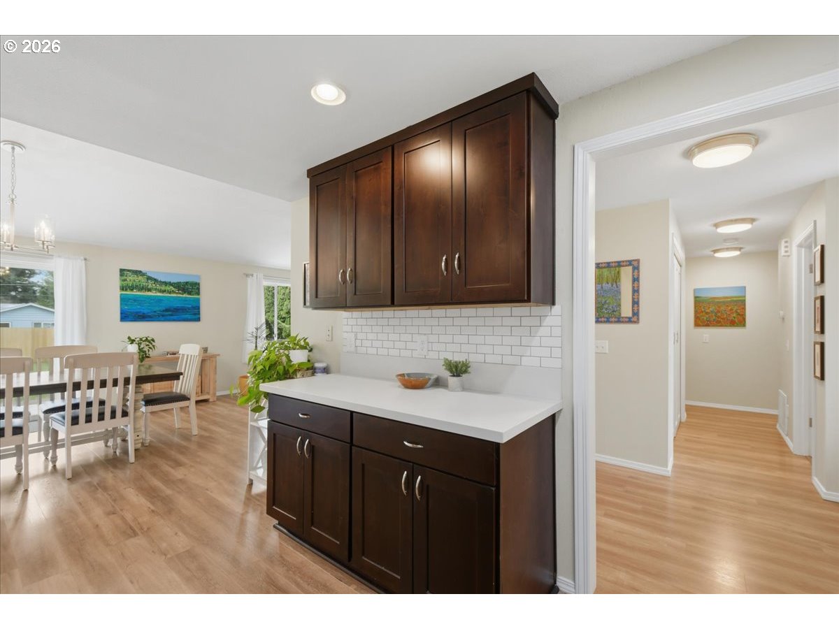 4620 Southwest 183rd Court Beaverton, OR 97078 - Photo 10 of 34 a kitchen with stainless steel appliances granite countertop a sink dishwasher and a dining table with wooden floor