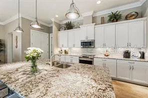 a kitchen with stainless steel appliances kitchen island granite countertop a sink a stove and cabinets