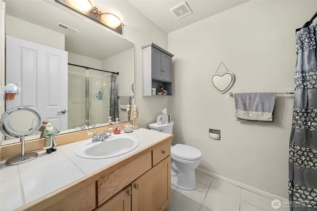 a bathroom with a sink toilet a mirror and shower