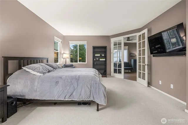 a spacious bedroom with a bed a table and large window