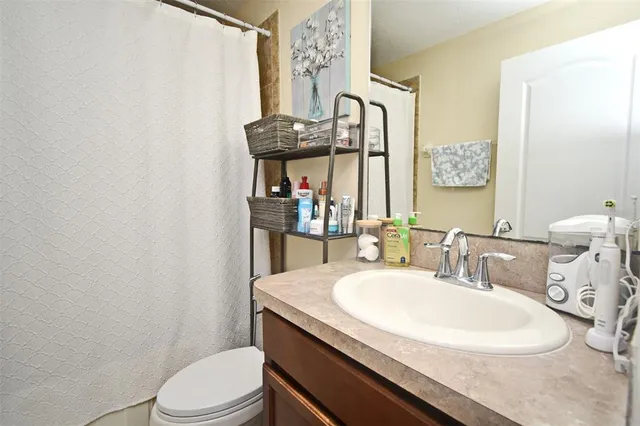a bathroom with a granite countertop toilet sink and mirror