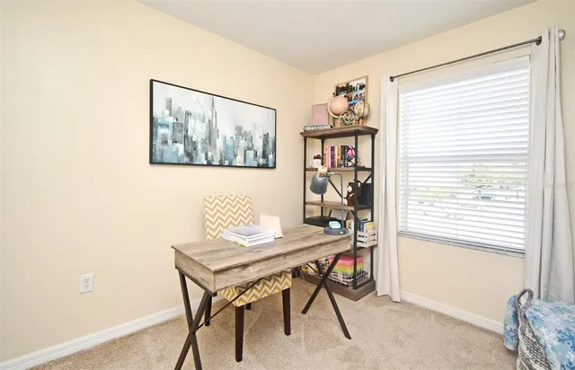 a view of a workspace with furniture and a window