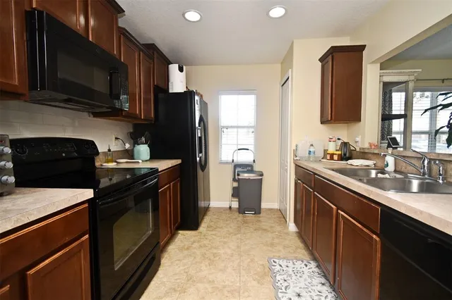 a kitchen with stainless steel appliances granite countertop a refrigerator a stove top oven a sink and dishwasher