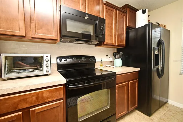 a kitchen with stainless steel appliances granite countertop a refrigerator stove and microwave