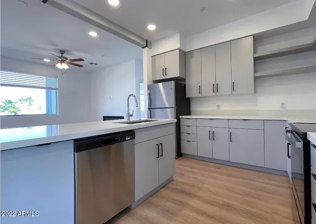 a kitchen with granite countertop a sink cabinets stainless steel appliances and a counter space