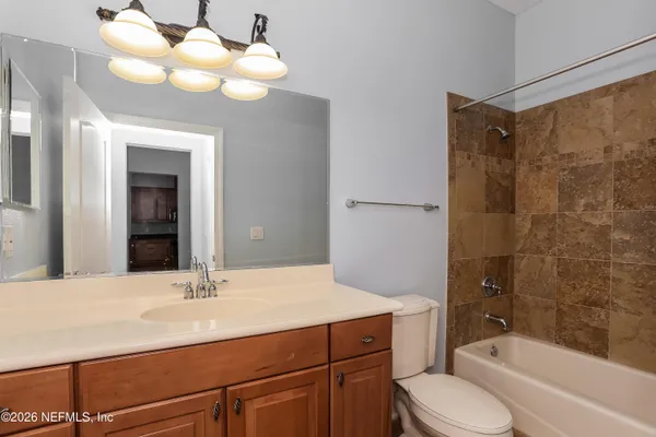 a bathroom with a sink vanity granite toilet tub and shower