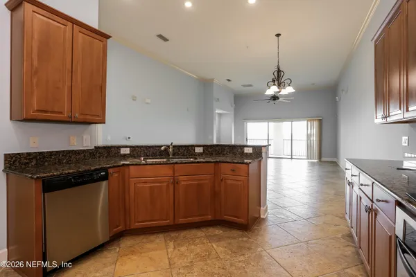 a kitchen with stainless steel appliances granite countertop a sink a stove top oven a counter space and cabinets