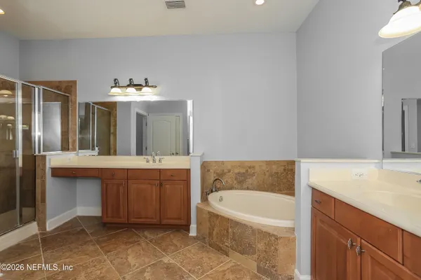 a bathroom with a tub sink and mirror
