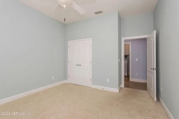 a view of an empty room with a ceiling fan