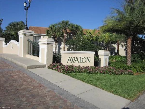 a sign board with buildings in the background