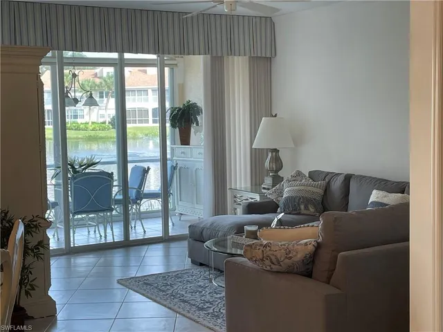 a living room with furniture and a floor to ceiling window