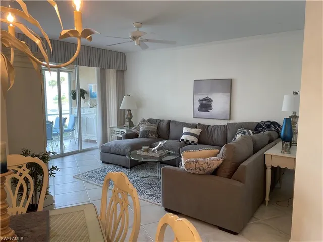 a living room with furniture gym equipment and a chandelier