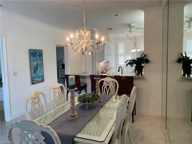 a view of a dining room with furniture a chandelier and wooden floor