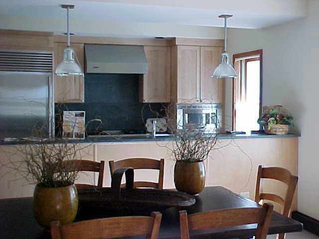 368 South Davis Street, Unit A7 Telluride, CO 81435 - Photo 7 of 9 a kitchen with stainless steel appliances granite countertop a table chairs in it and wooden floors