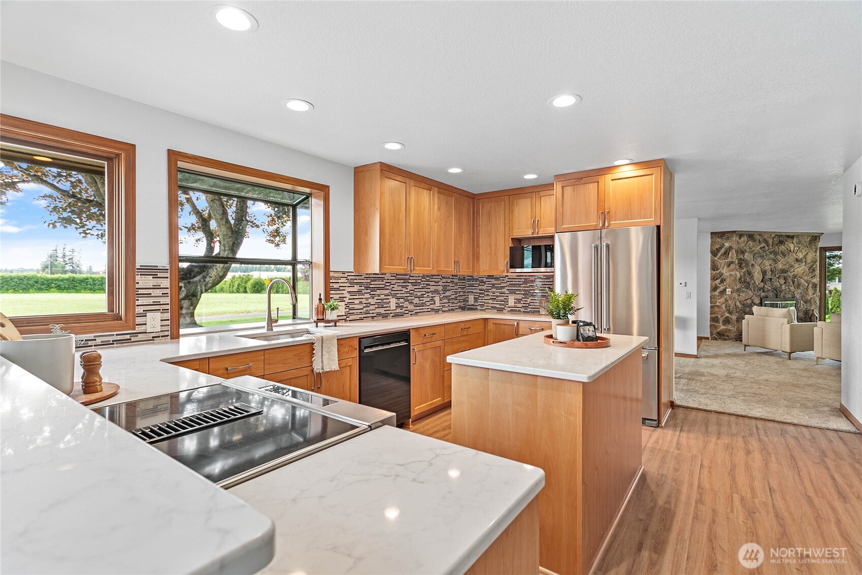 1133 East Pole Road Everson, WA 98247 - Photo 15 of 40 a kitchen with stainless steel appliances a sink a stove a refrigerator cabinets and a dining table with wooden floor